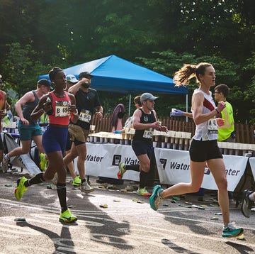 a group of runners grab water during a race