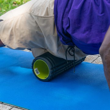 a person using a foam roller on their thigh