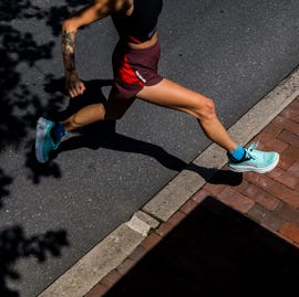 a woman running in a pair of hoka running shoes